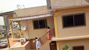A multi-story residential building with a balcony, a staircase, and a door marked "Christmas." - Feehi's Place - Hostel (Accra)