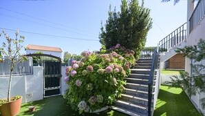 A staircase leading up to a building with a white exterior and a black gate. - Casa das Hortênsias - Charming Guest House (Sintra)