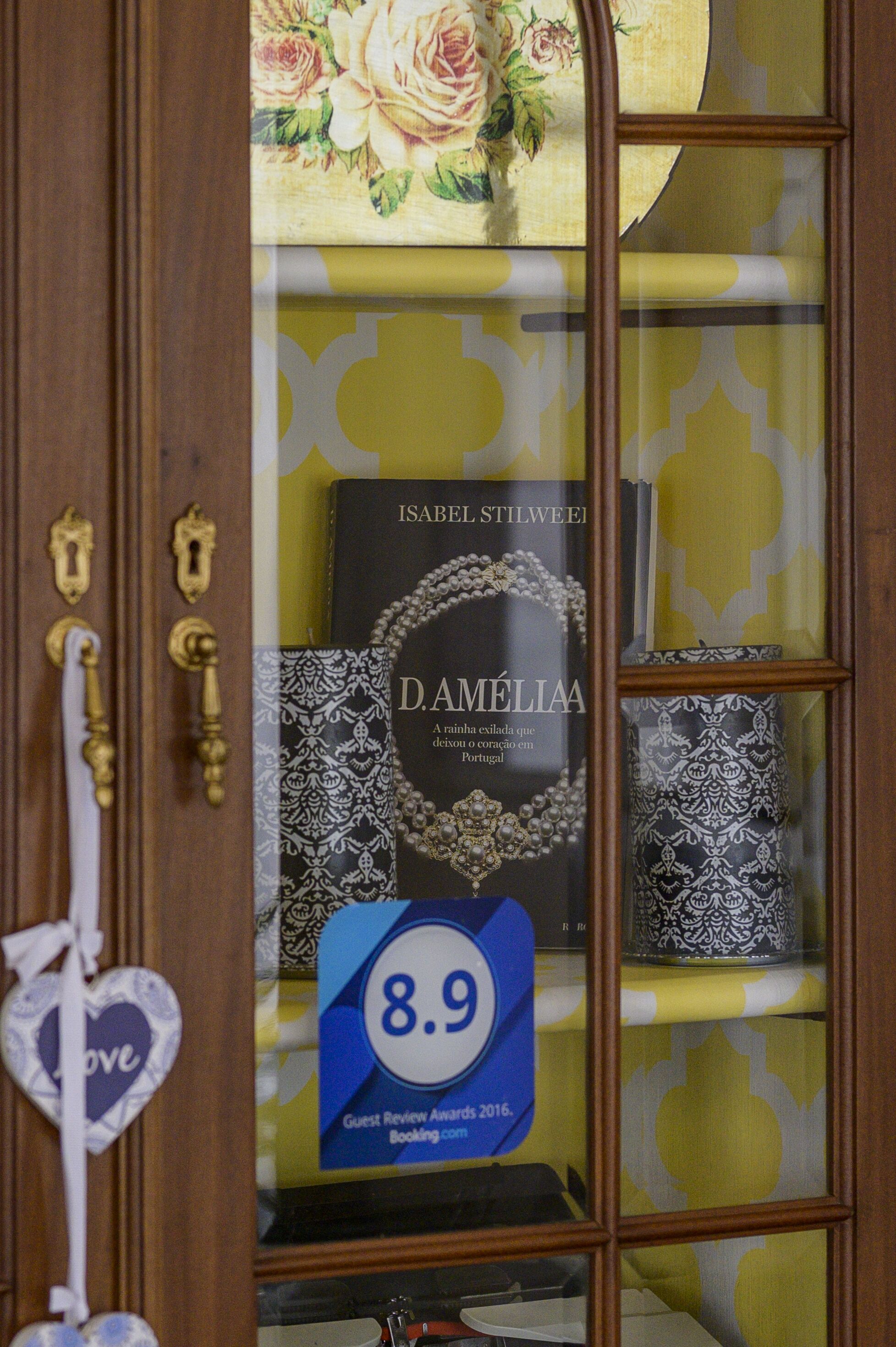 Una vitrina con un libro titulado 'D. Damelia' y un cartel que dice 'Premios por las Reseñas de los Huéspedes 2016'.