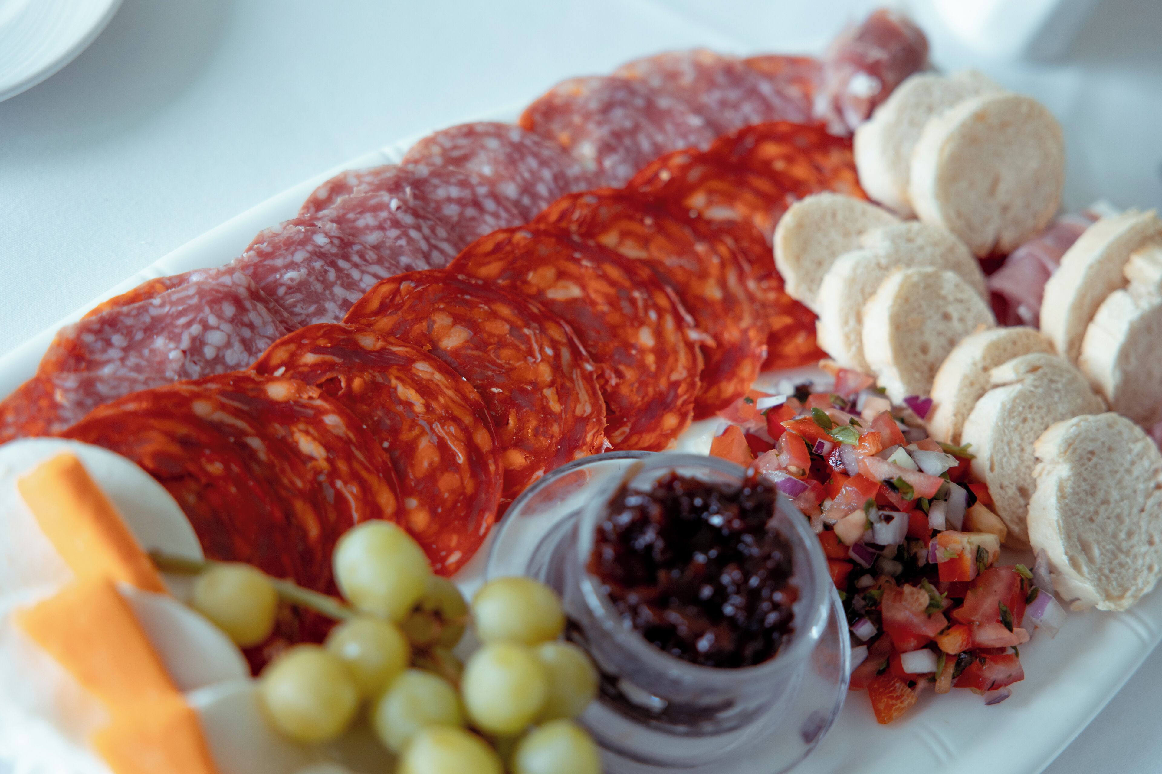A charcuterie board with various meats, cheeses, and accompaniments.