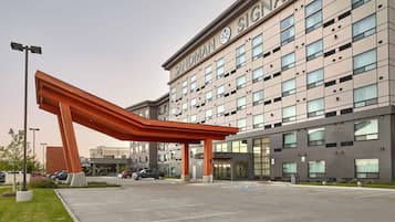 Un edificio moderno con una entrada destacada y una gran estructura curva en primer plano.