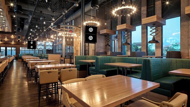 A modern restaurant interior with wooden tables and green booths, large windows, and industrial-style lighting. - Sandman Signature Plano - Frisco Hotel (Plano)