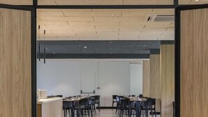 A modern conference room with a long table and chairs, wooden panel walls, and a tiled floor. - Villa Delle Rose (ARCO)