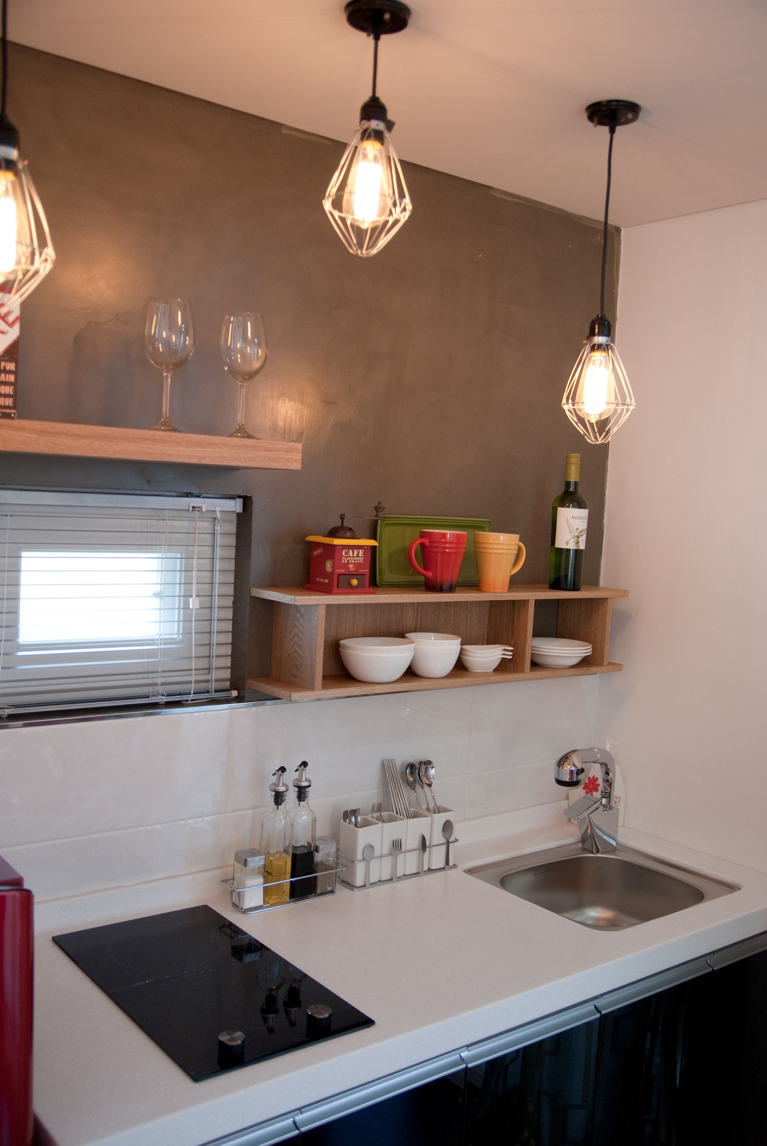 Una cocina moderna con encimera, lavabo e iluminación colgante.