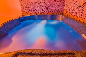 Un jacuzzi con un muro de mosaicos.