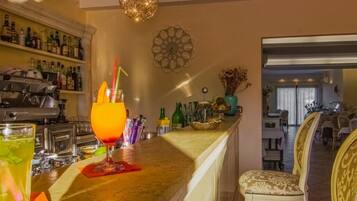 Eine Bar mit einer Theke, Barhocker und einer dekorativen Pendelleuchte.