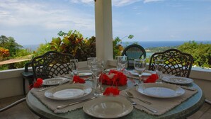 A round table set for dining with a view of the ocean. - Tranquility Villa (Port Antonio)