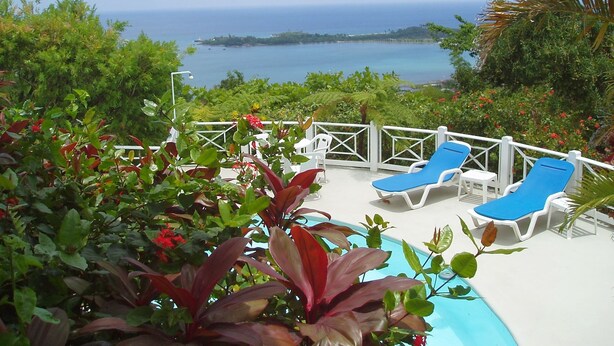 A pool area with lounge chairs and a view of the ocean. - Tranquility Villa (Port Antonio)