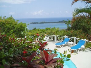 A pool area with lounge chairs and a view of the ocean. - Tranquility Villa (Port Antonio)