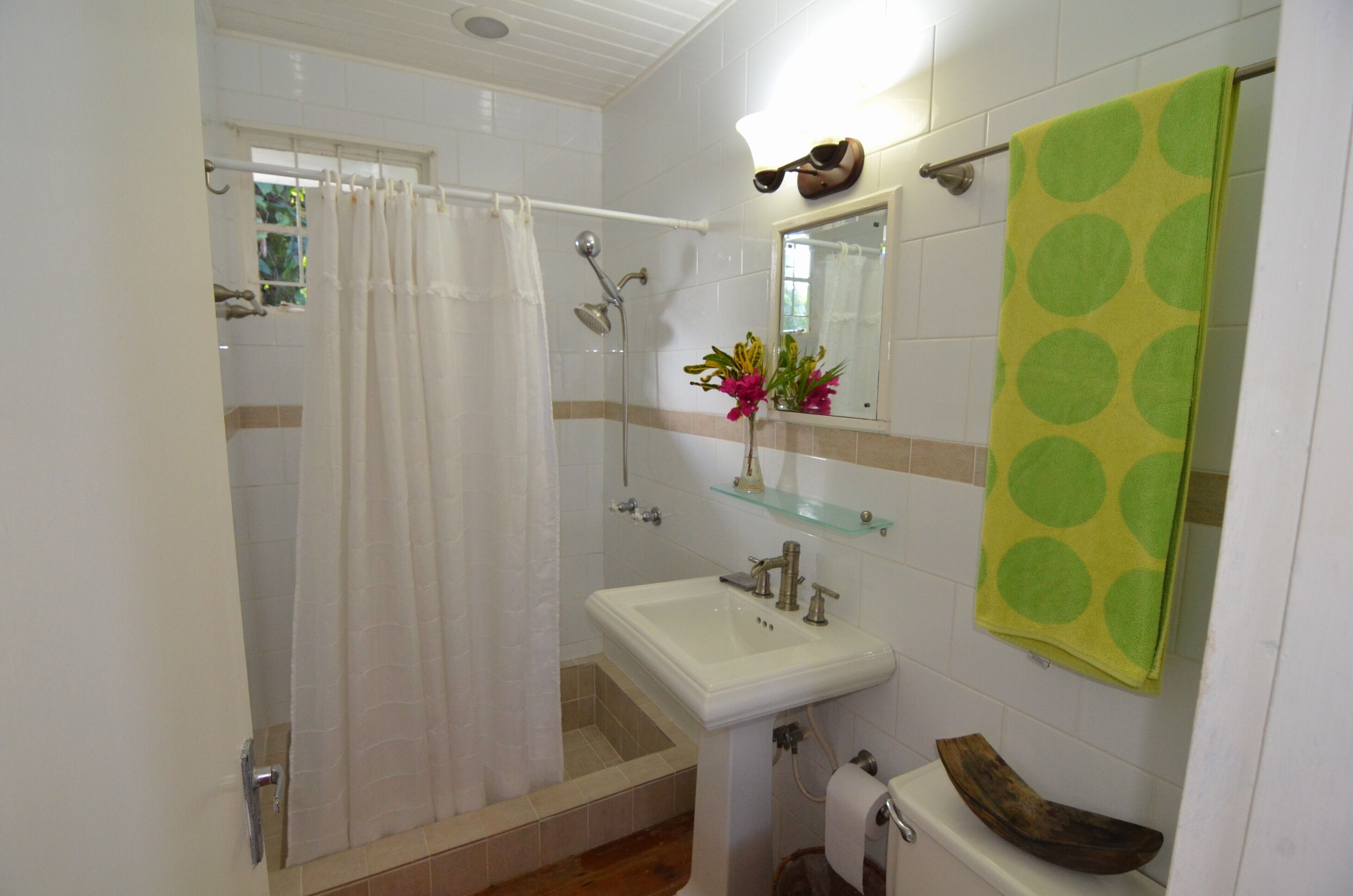 Un baño con ducha, lavamanos e inodoro.