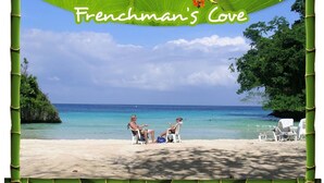 A beach scene with two people sitting on chairs under a green canopy, with a clear blue sky and calm sea in the background. - Tranquility Villa (Port Antonio)