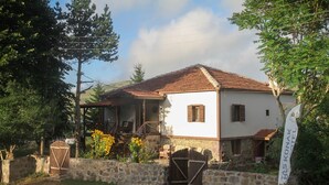 A two-story stone building with a tiled roof, a wooden gate, and a flag indicating it's a hotel. - Tas Konak Butik Otel (Aybasti)