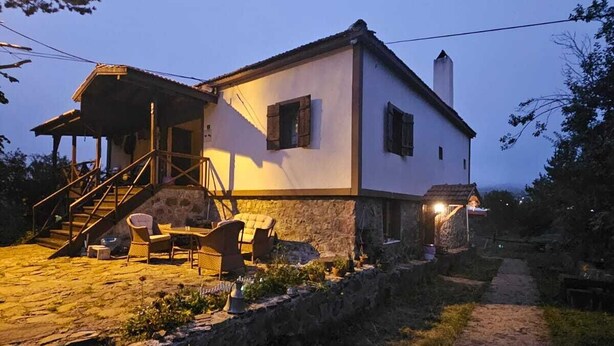 A two-story house with a stone pathway leading to a wooden deck with outdoor furniture. - Tas Konak Butik Otel (Aybasti)