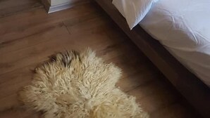 A bedroom with a bed, a door, a wall-mounted light fixture, and a fluffy rug. - Tas Konak Butik Otel (Aybasti)