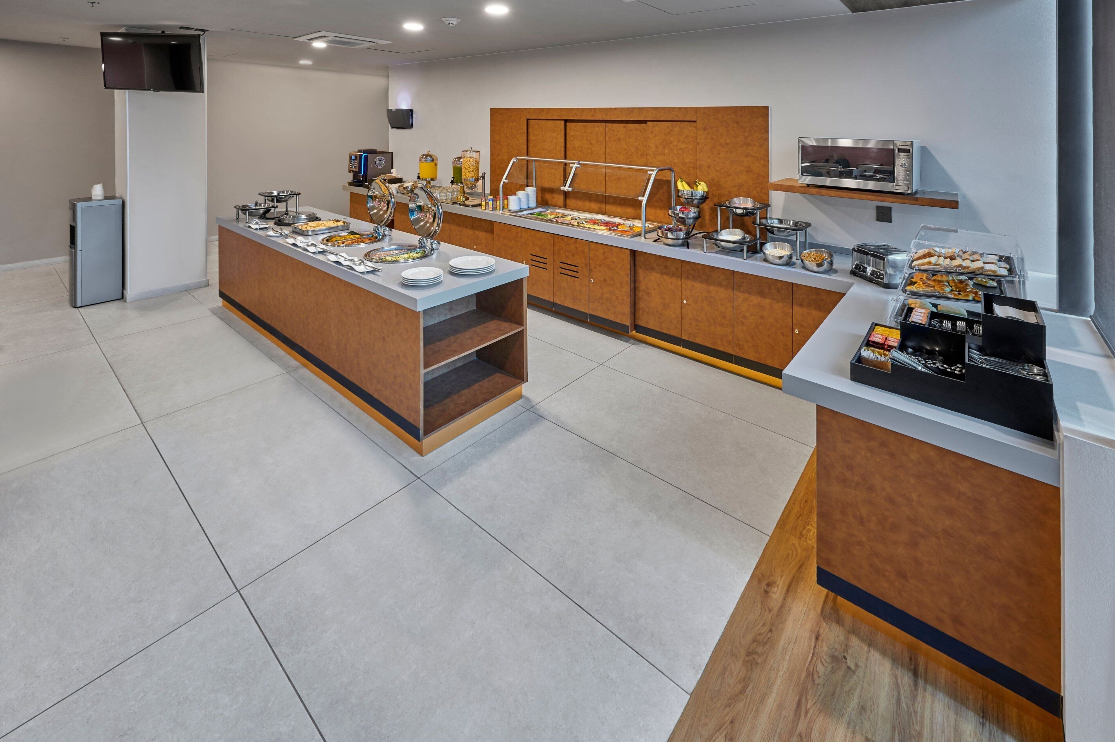 A modern breakfast buffet with a variety of food items, a coffee station, and a microwave.
