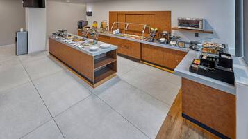 A modern breakfast buffet with a variety of food items, a coffee station, and a microwave.