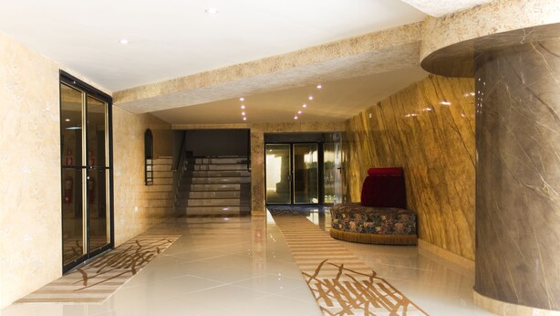 A spacious lobby with a marble column, a staircase, and a plush seating area. - Hotel Casa Miller (Panama City)