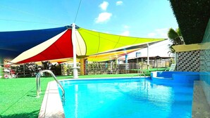 A swimming pool with a clear blue water surface, surrounded by a stone deck. - Hotel Casa Miller (Panama City)