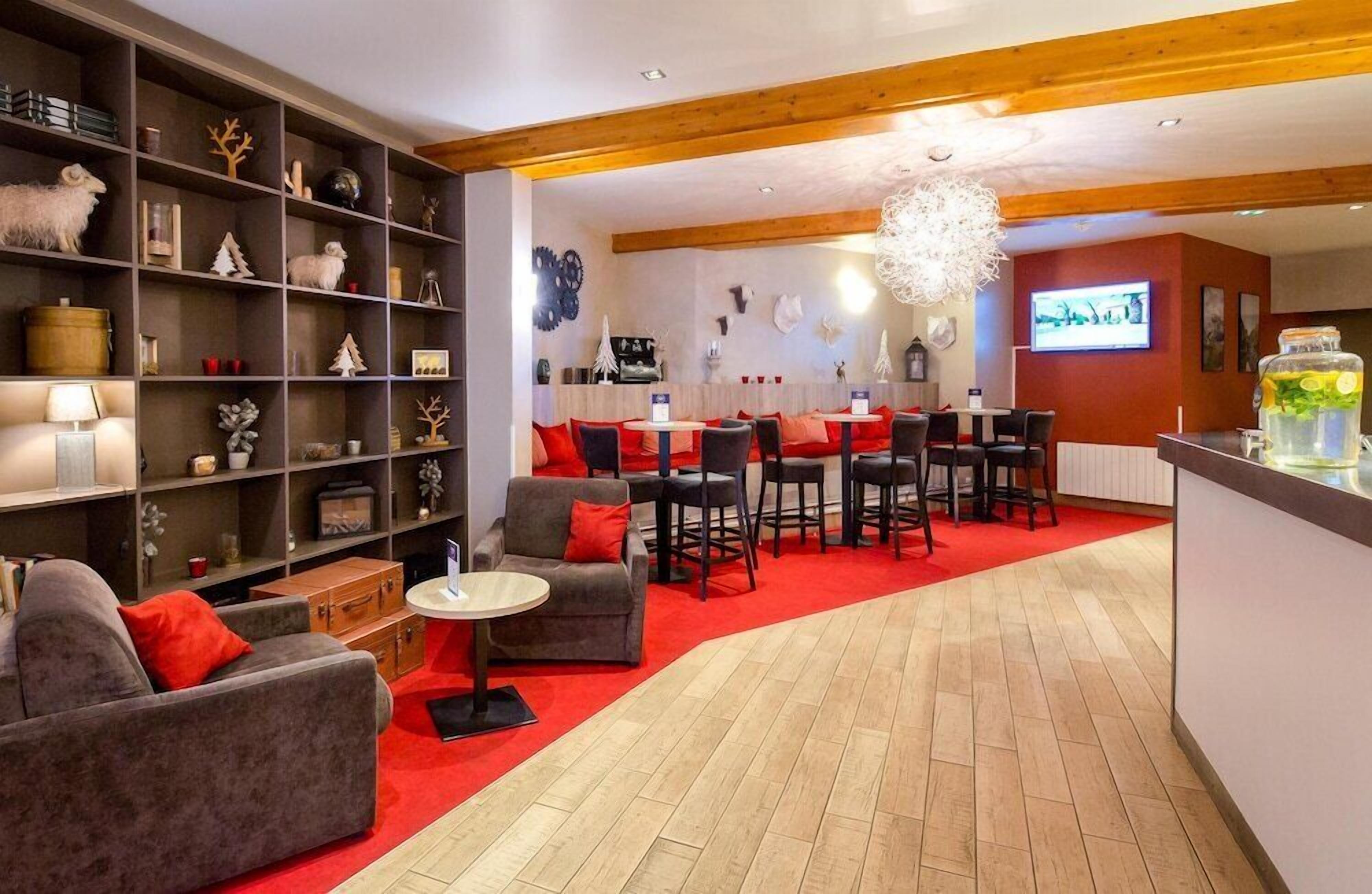 Un interno moderno con una zona salotto, un bar e una libreria piena di oggetti decorativi.
