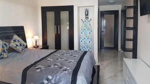 Une chambre à coucher avec un lit, une armoire, un miroir et un luminaire au plafond.