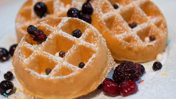 Dos waffles con azúcar glas y frutos rojos.