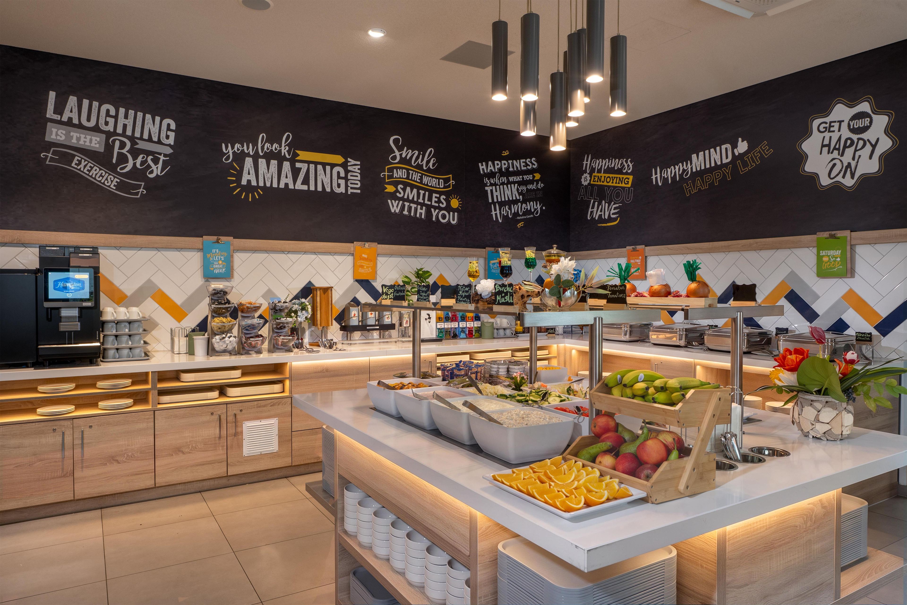 Una barra de desayuno moderna con diversas opciones de comida, como frutas, verduras y bebidas.