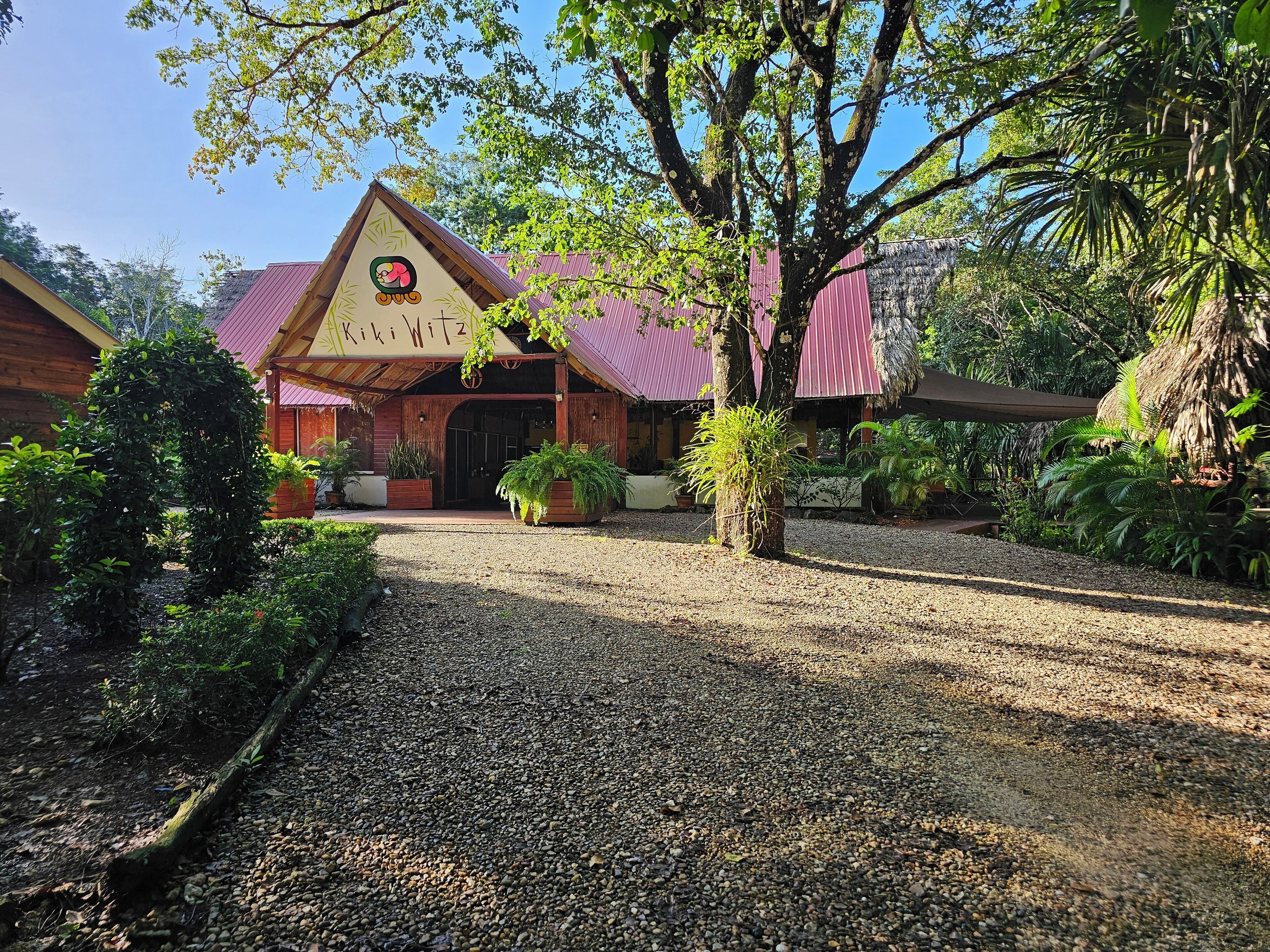A rustic building with a red roof and a sign that reads "Kiki Witz".