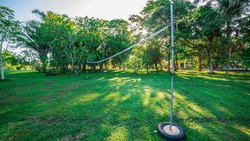 A grassy area with a rope barrier, trees, and a clear sky.