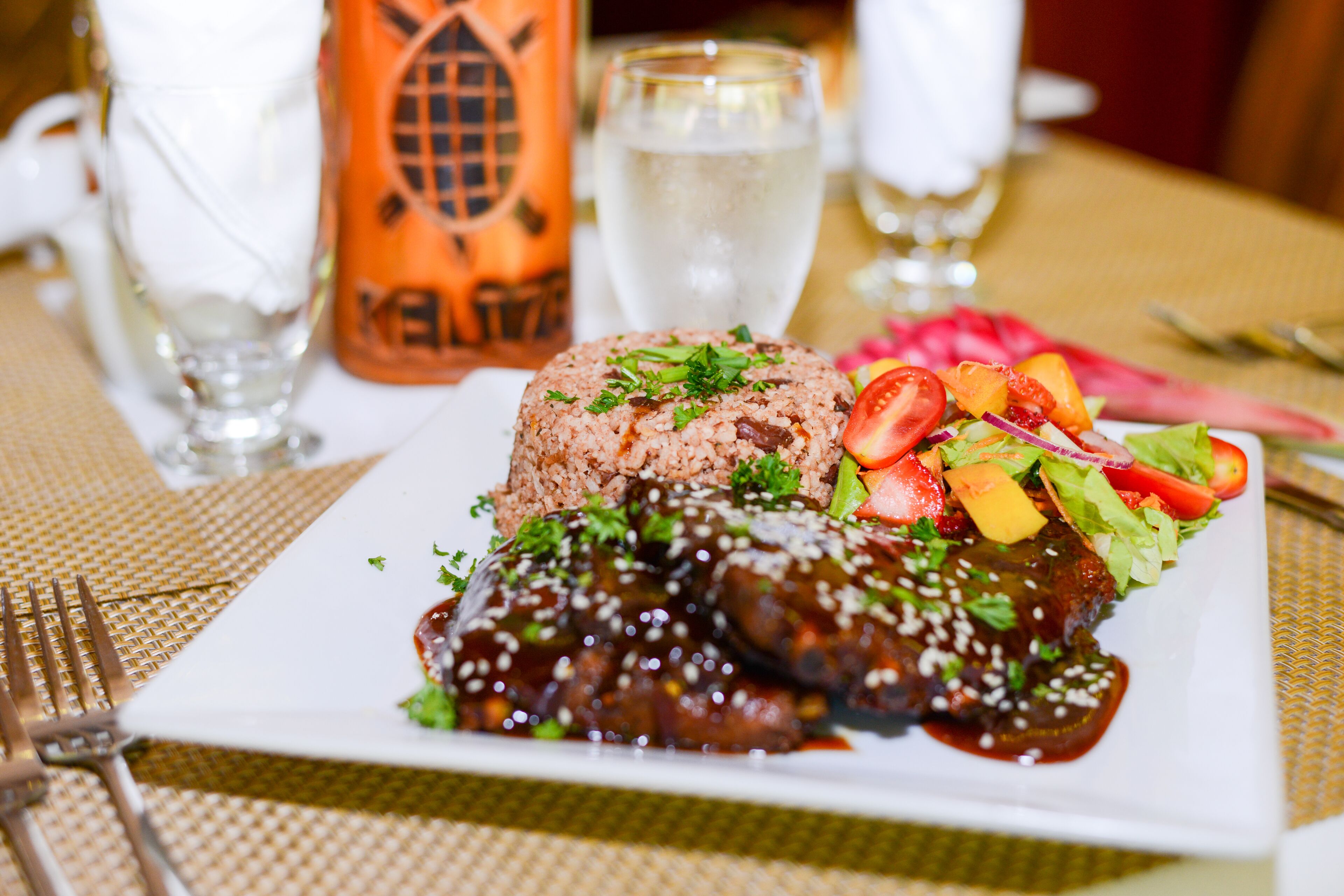 A plate of food with rice, meat, and vegetables.