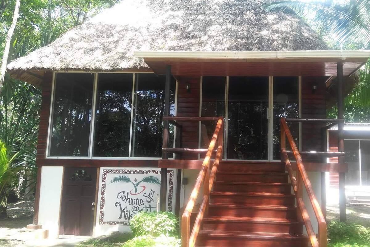 A building with a thatched roof, wooden staircase, and a sign for a spa.
