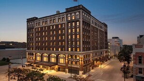 A historic hotel with a classic architectural design, featuring multiple floors and a prominent entrance with outdoor seating. - Hotel Northland, Autograph Collection (Green Bay)
