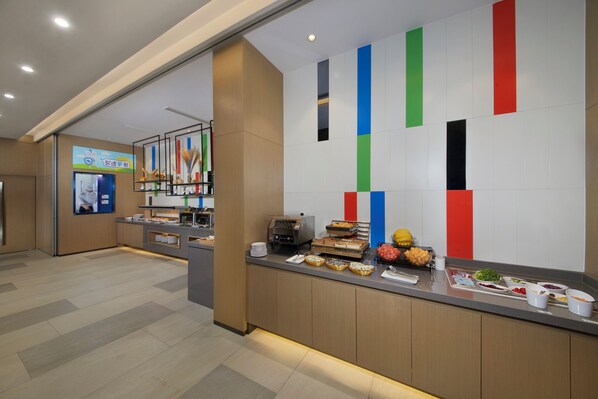 A buffet area with a variety of food options and a wall with vertical stripes. - Holiday Inn Express Zhangjiagang East by IHG (Suzhou)