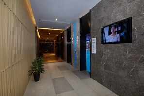 A hotel lobby with a reception desk, a television screen, and a directory sign. - Holiday Inn Express Zhangjiagang East by IHG (Suzhou)