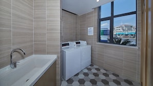 A modern bathroom with a large window, a built-in washing machine, and a sink. - Holiday Inn Express Zhangjiagang East by IHG (Suzhou)