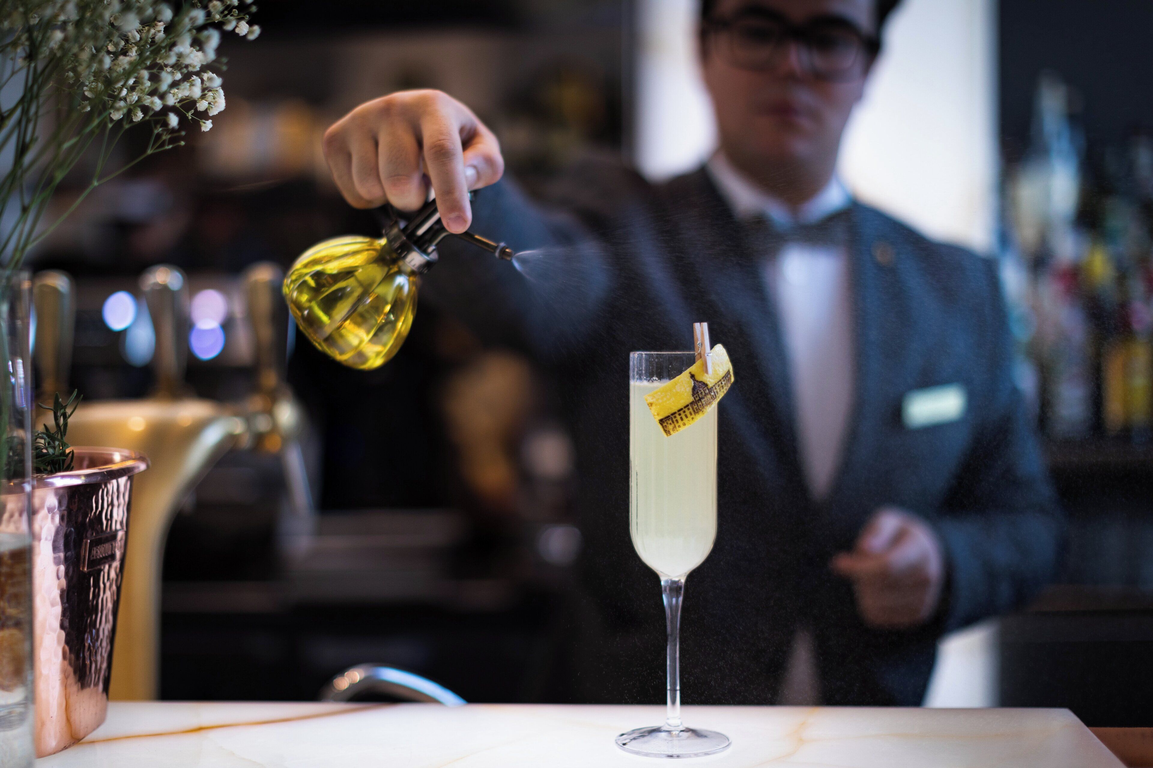 Un bar, avec un barman en train de verser une boisson dans un grand verre.