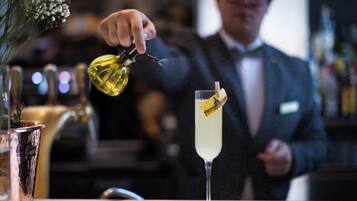 Un bar, avec un barman en train de verser une boisson dans un grand verre.