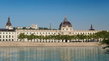 A large building with a prominent dome and a river in the foreground.