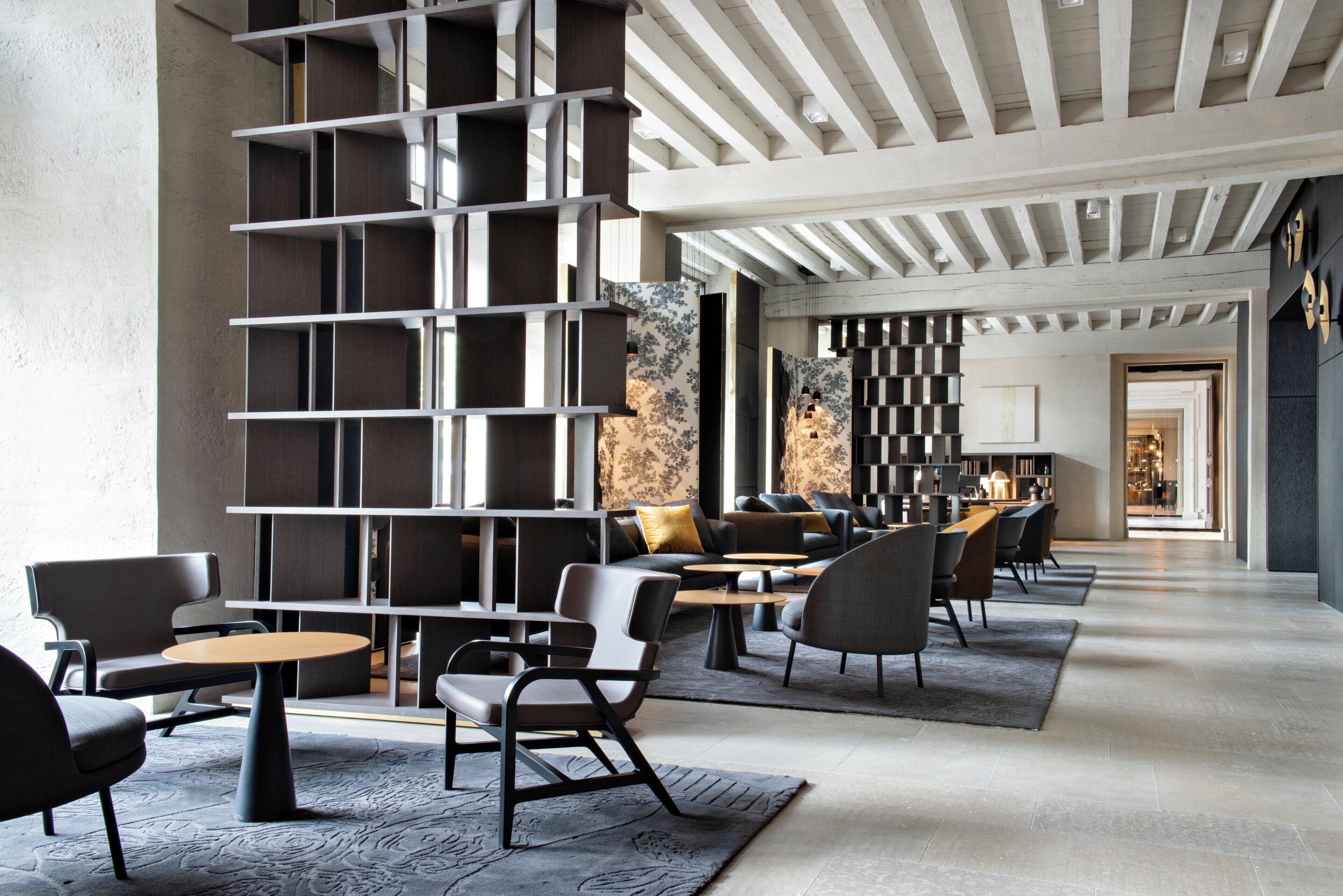 Decoração moderna com estante central, área de estar e vista para a sala de jantar.