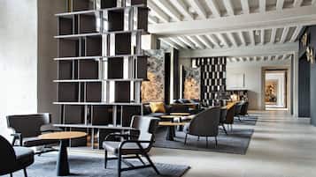 Decoração moderna com estante central, área de estar e vista para a sala de jantar.