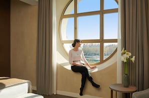 Una donna seduta vicino a una grande finestra con vista sulla città.