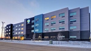 A multi-story hotel with a modern design, featuring a prominent logo on the facade. - TRU BY Hilton Edmonton Windermere (Edmonton)