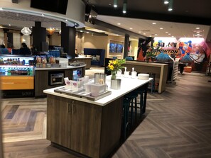 A modern hotel lobby with a central island, seating area, and a vending machine. - TRU BY Hilton Edmonton Windermere (Edmonton)