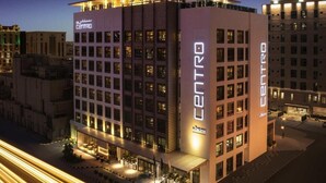 Un hotel moderno con un llamativo letrero 'CENTRO', que presenta una estructura de varios pisos con techo plano y entrada a nivel de calle.