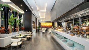 Un moderno vestíbulo de hotel con un mostrador de recepción alargado, zona de estar y un bufé.