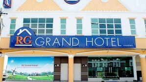 A hotel with a prominent 'RG Grand Hotel' sign, a large window display, and a 'Hotel' sign on the left. - RG Grand Hotel (Batu Pahat)