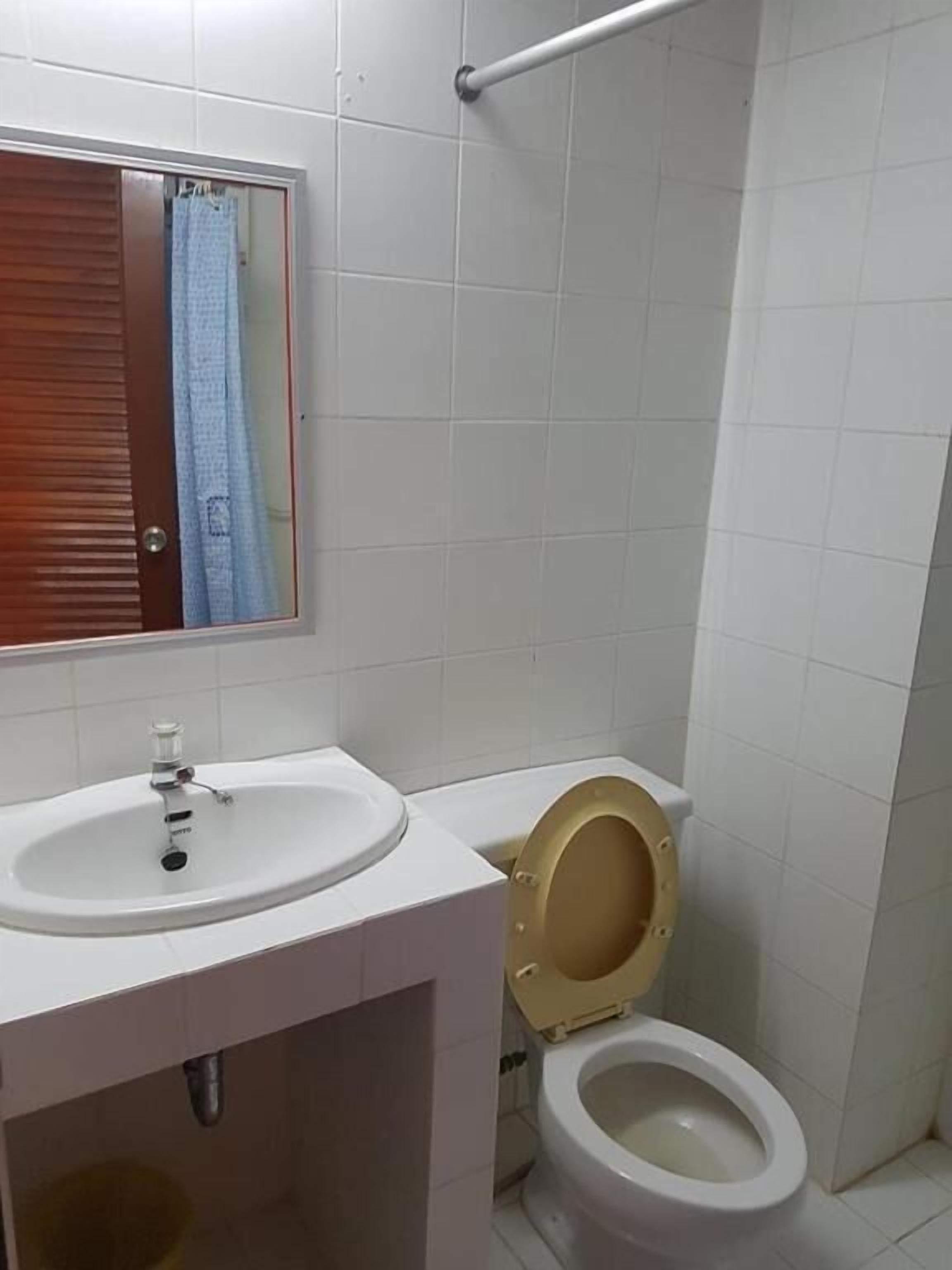 A bathroom with a white sink, a toilet, and a mirror above the sink.