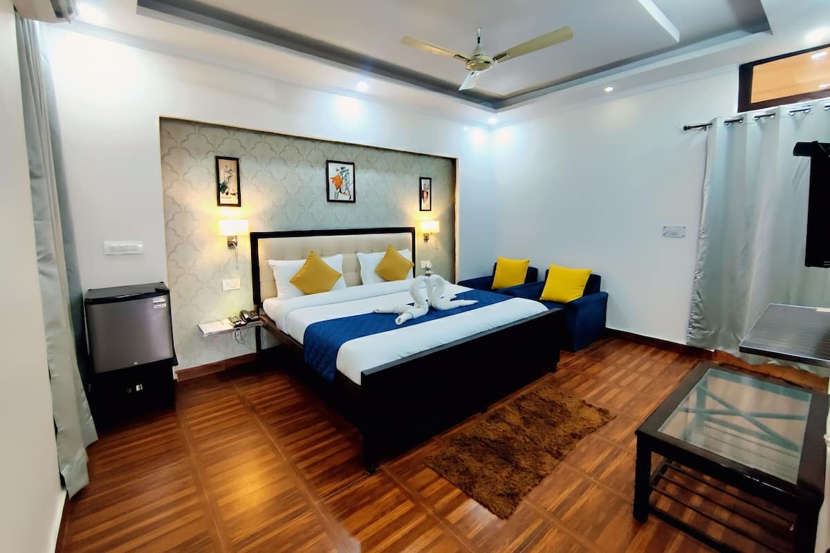 A hotel room with a bed, bedside table, lamp, and a ceiling fan.