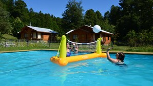 Una piscina con una red flotante y una estructura inflable.