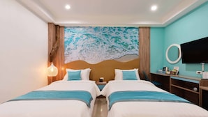 Habitación de hotel con dos camas, un mural grande, un televisor y un escritorio con un espejo.