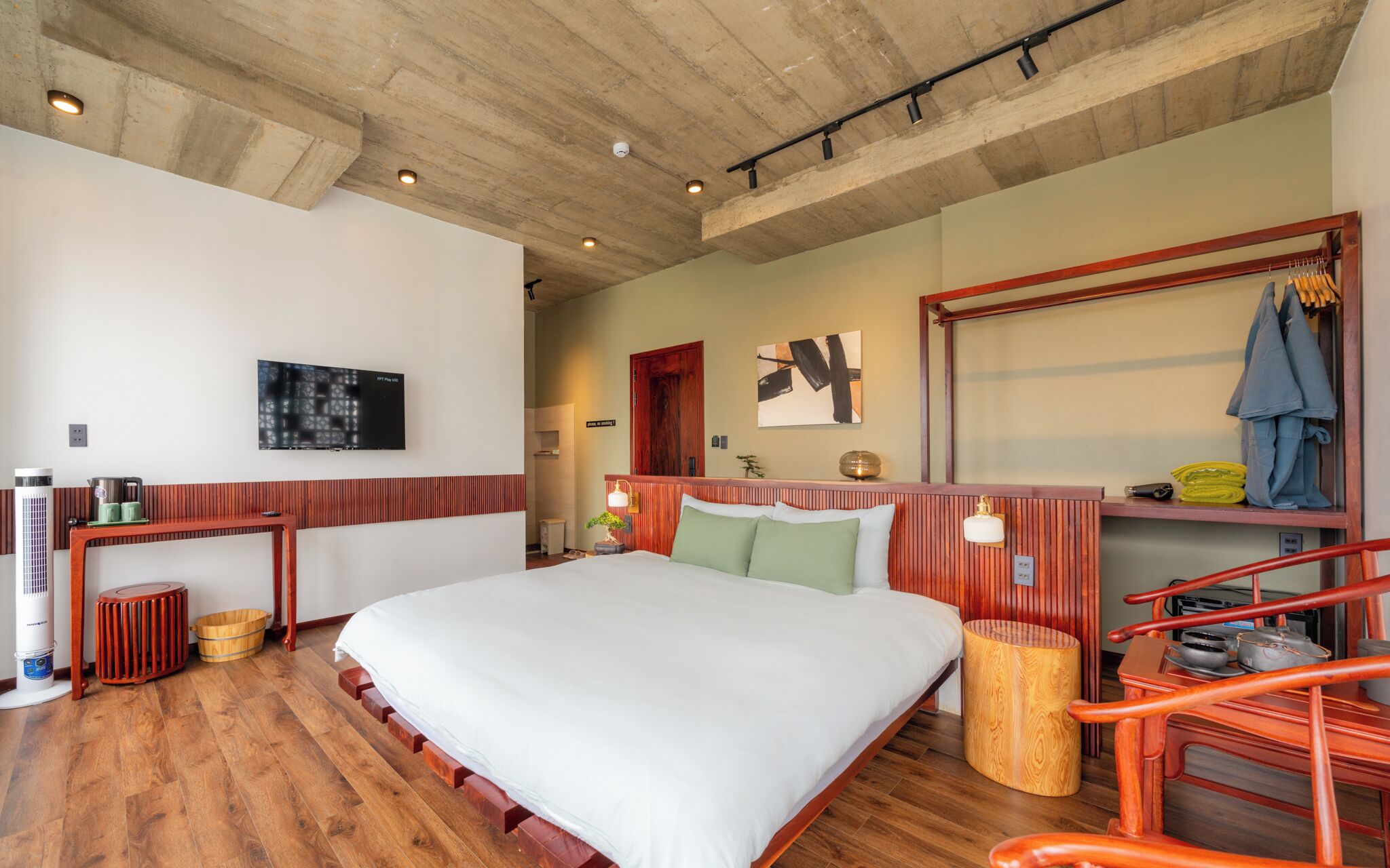 Une chambre d’hôtel avec un grand lit, des boiseries, une télévision, un bureau et une chaise.
